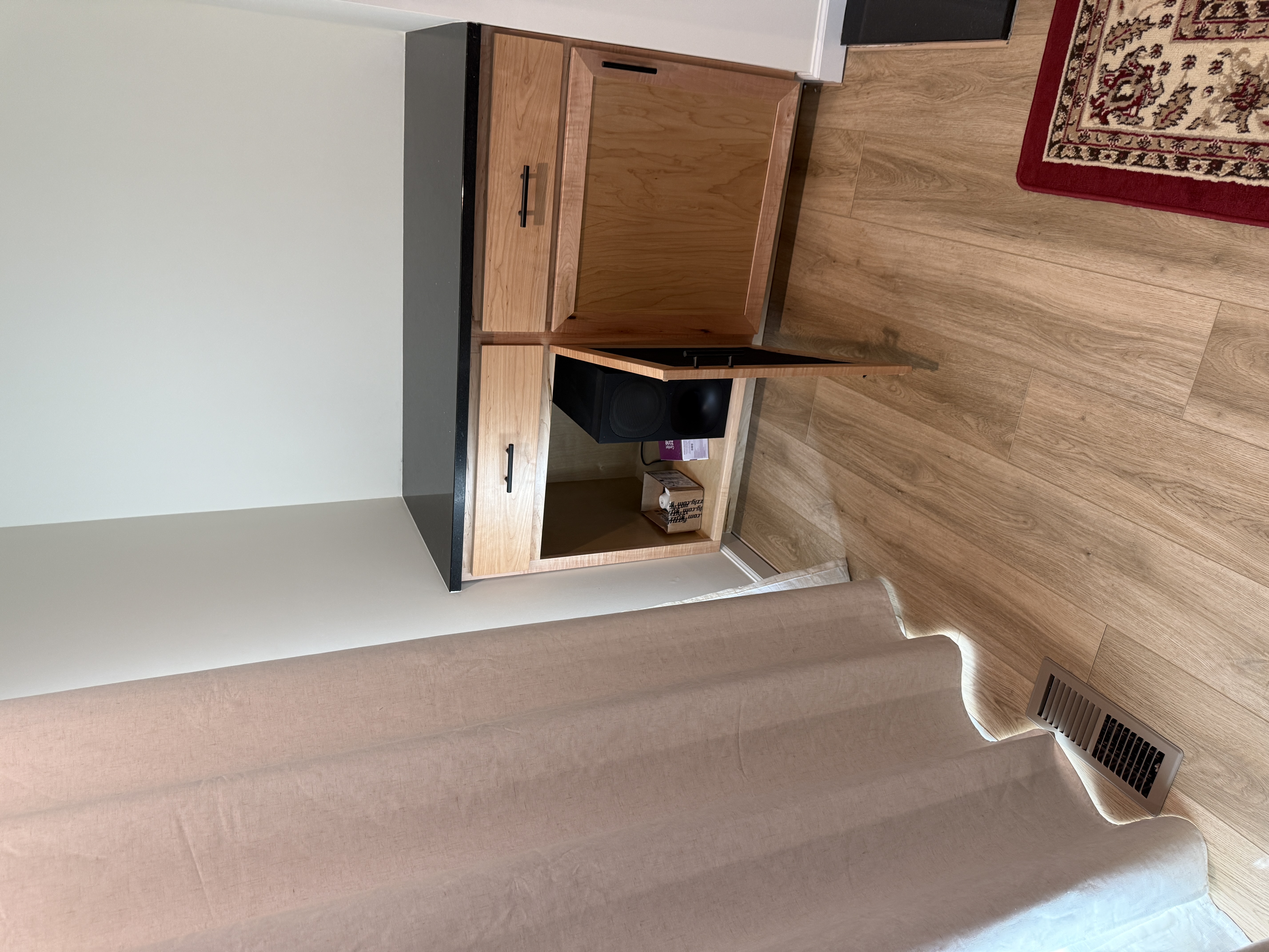 Open custom cabinet showing concealed audio equipment storage